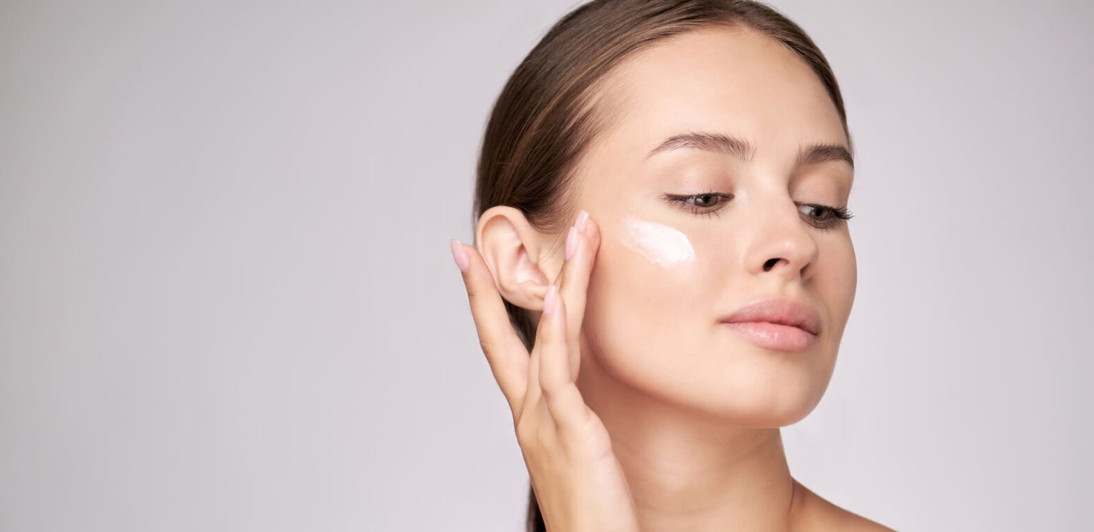 Frau benutzt Creme mit Glucosamin