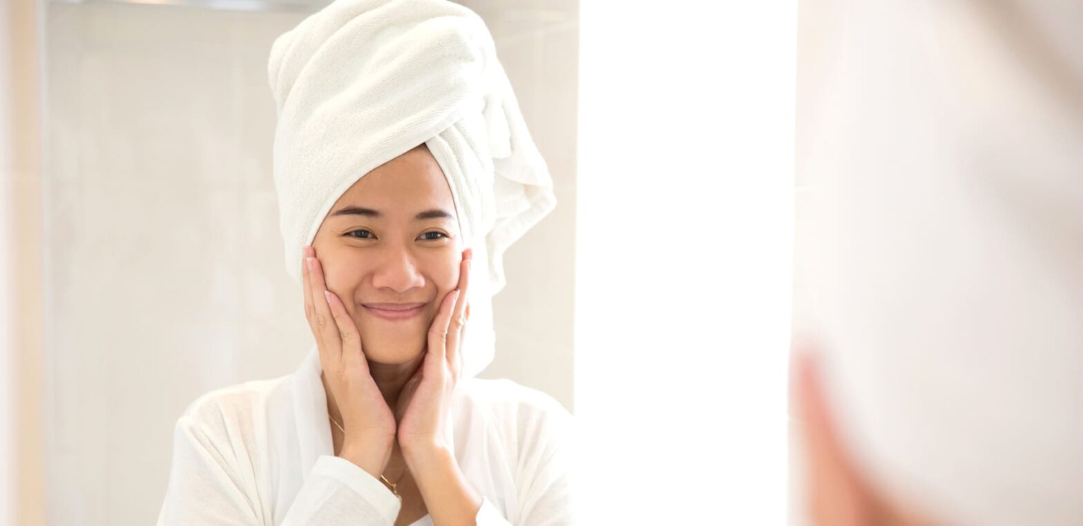 Frau mit reiner Haut im Bad.