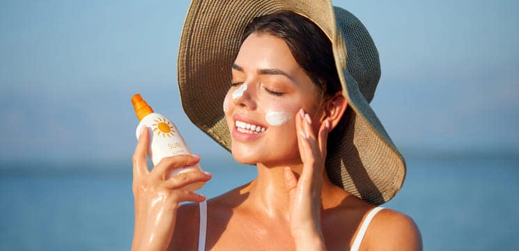 Frau nutzt Sonnencreme mit Retinol.